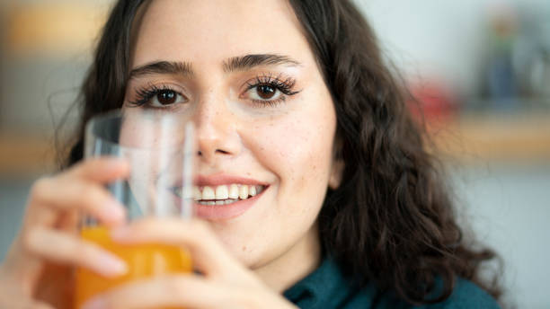istock Young woman drinking orange juice 1393418765
