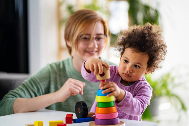 istock Mother looking at a child playing with an educational didactic toy 1393418777
