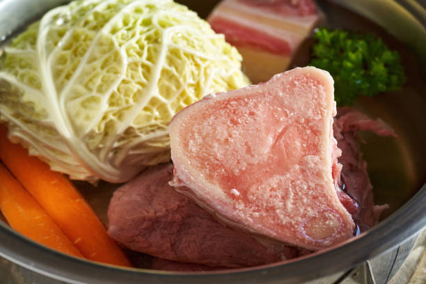 istock Ingredients for preparing beef bone broth - marrow bones and vegetables in a pot 1393423204