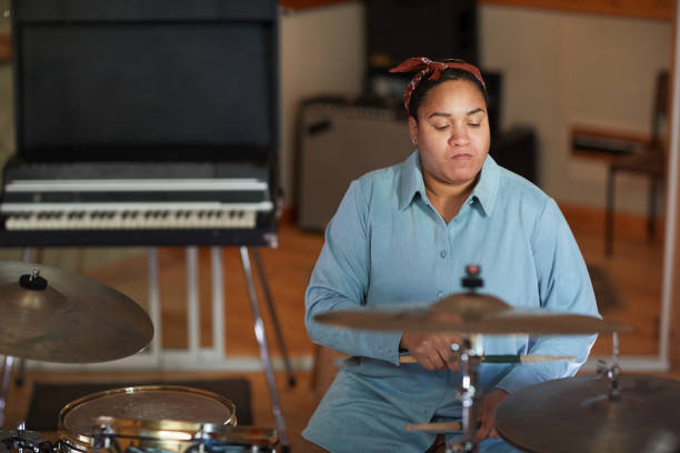 istock Woman Playing Drums in Recording Studio 1393425429