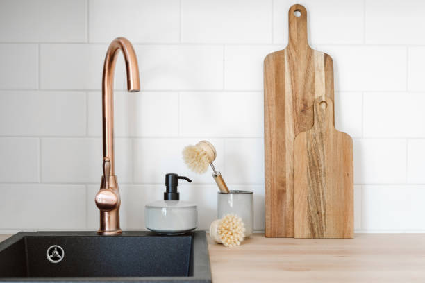 household objects standing near black modern sink with copper faucet - 洗碗刷 個照片及圖片檔