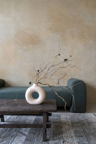 istock Ceramic vase with dry tree branch on table against couch 1393432889