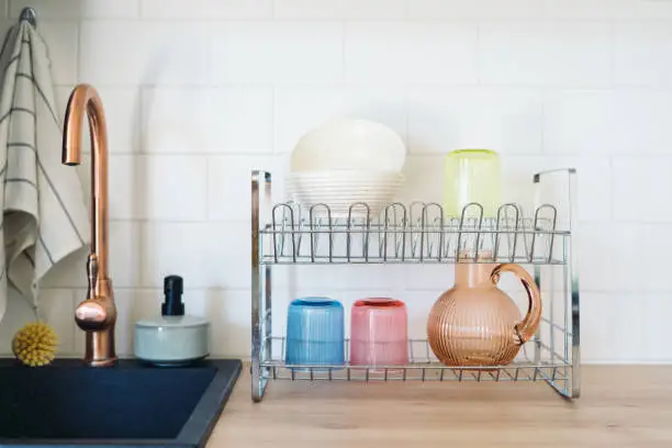 Photo of Metal drying rack with clean washed dishes