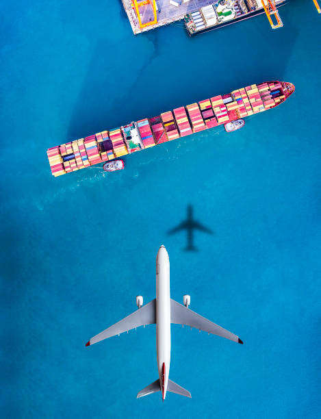 airplane flying above cargo ship. - travel nautical vessel commercial dock pier imagens e fotografias de stock