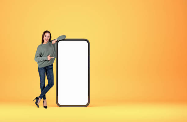 istock Woman point at phone mockup display on bright background 1393436326