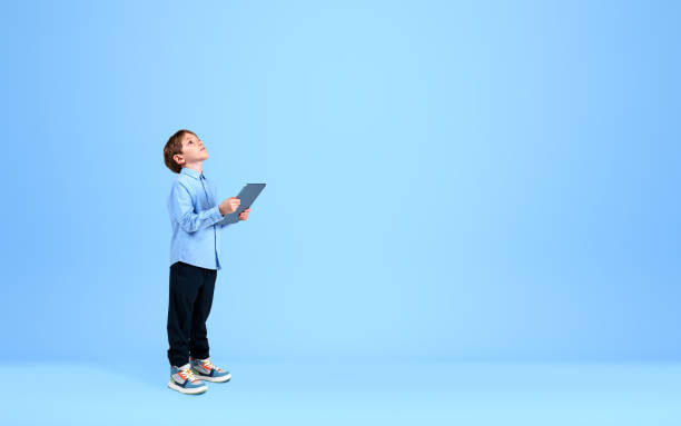 istock Handsome boy wearing formal shirt is holding tablet device 1393436392