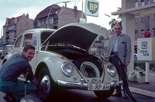 Berlin (West), Germany, 1967. Gas station service. Refueling and checking tire pressure at a gas station.