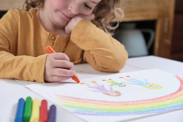 istock Thoughtful child drawing LGBT family with crayons 1393446330