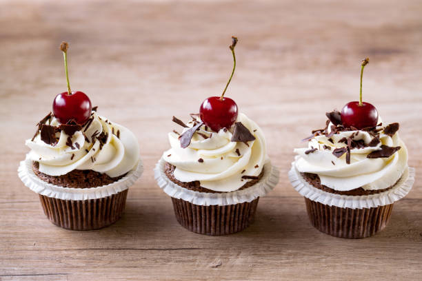 istock fresh chocolate cupcakes with white cream and cherry 1393448506