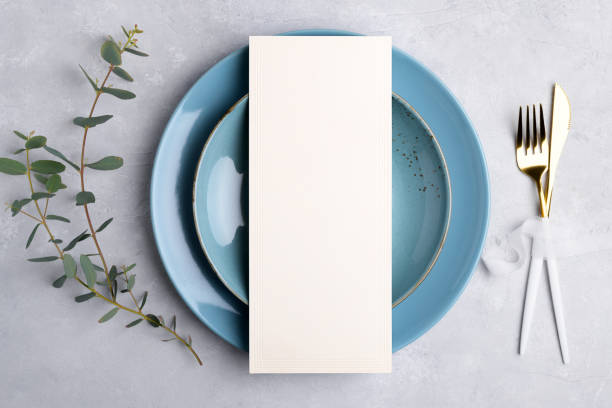 istock Menu card mockup on blue plate with festive wedding or birthday table setting with eucalyptus branch on grey background 1393448524