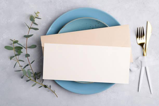 istock Invitation card mockup with envelope on blue plate with festive table setting with eucalyptus branch on grey background 1393448530