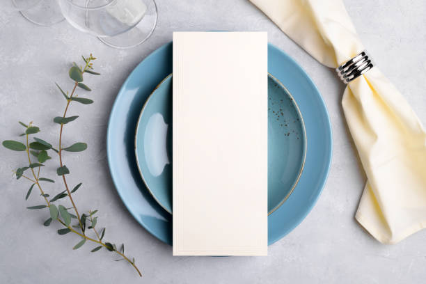istock Menu card mockup on blue plate with festive wedding or birthday table setting with eucalyptus branch on grey background 1393448534