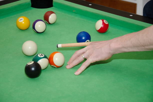 istock Hand with cue aiming on billiard ball at table 1393460400