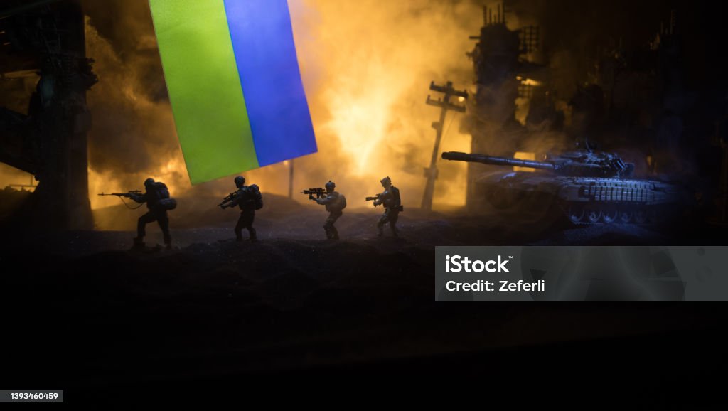 Russian war in Ukraine concept. Silhouette of armed soldiers against Ukrainian flag and burned out city. Creative artwork decoration. Night fighting scene Russian war in Ukraine concept. Silhouette of armed soldiers against Ukrainian flag and burned out city. Creative artwork decoration. Night fighting scene. Selective focus Armed Forces Stock Photo