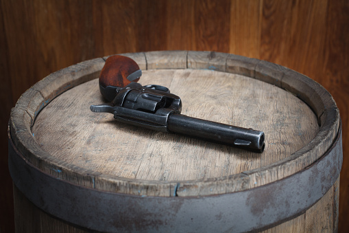 Old west revolver 45 cal on vintge wooden barrel