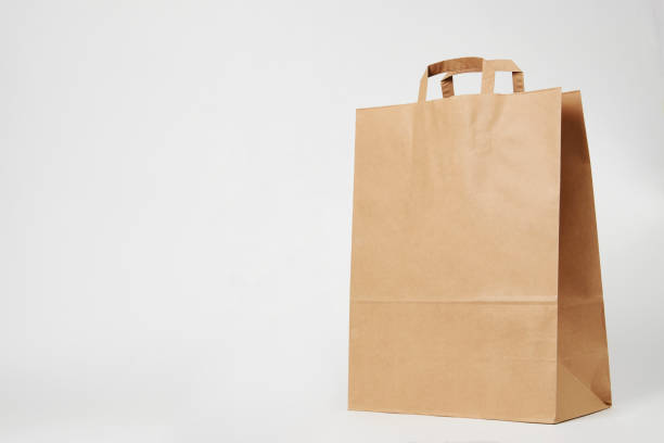 istock Brown paper bag on white background with copy space 1393472517