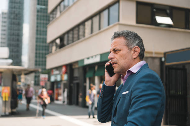 istock Mature man talking on cell phone downtown 1393482905