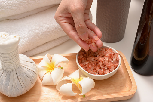 Close-up image, Female hands with Himalaya pink salt. Organic spa treatment table compositions.