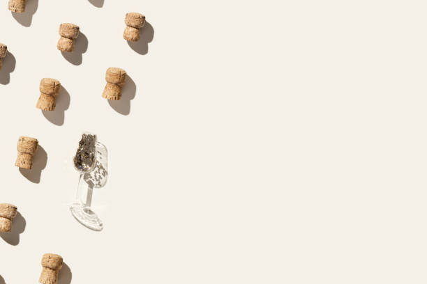 istock Creative pattern with champagne corks and festive wine glass with sparkles on beige background with hard light and shadows at sunlight. Minimal trend layout, bottle cap from sparkling wine 1393487192