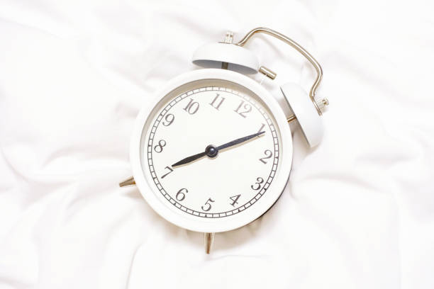istock Alarm clock on white background close-up, early rise concept. 1393490621