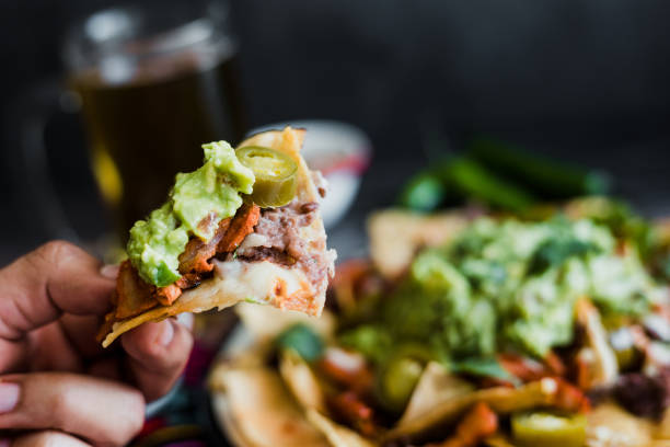 papas fritas de nacho mexicanas con queso americano y aguacate, comida tradicional en méxico latinoamérica - guacamole mexican cuisine avocado food fotografías e imágenes de stock