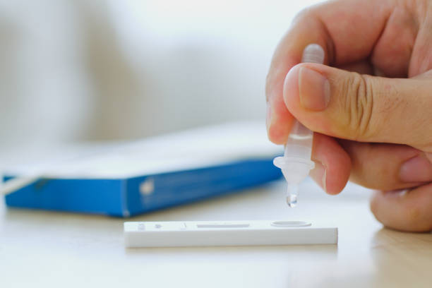 istock CLoseup hand using rapid antigen test kit (ATK) for self test at home. Dropping sample fluid on test kit. Pandemic of disease, covid-19, coronavirus 1393495923