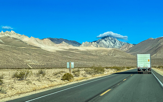 Trucking in the state of California on highway 395 with a view of the snow capped Sierra Nevada mountain range.