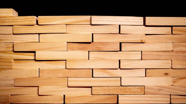 Stop motion of wooden brick forming into a wall