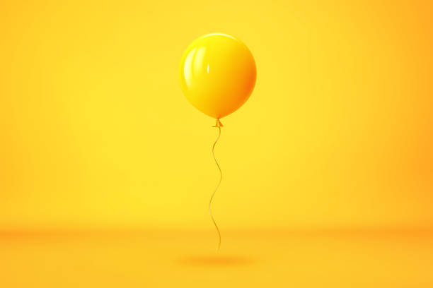 летающий желтый воздушный шар на желтом фоне - yellow balloon стоковые фото и изображения