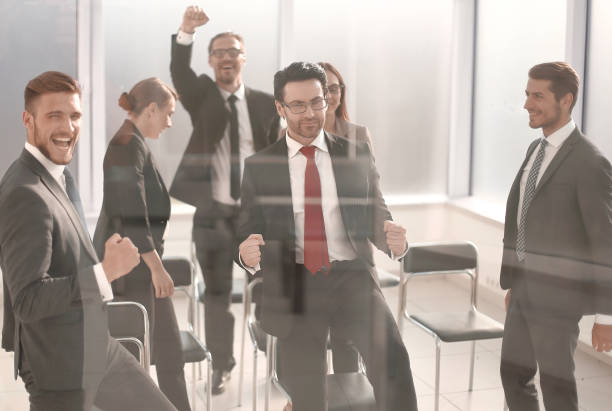 istock triumphant business team standing in the conference room 1393505921