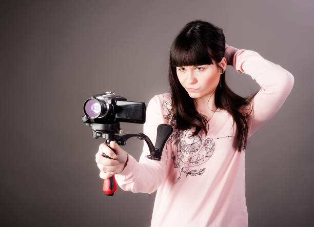 mujer joven con la cámara de vídeo - home video camera women videographer digital video camera fotografías e imágenes de stock
