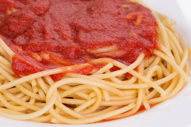 Fresh boiled spaghetti draining in metal colander, close-up