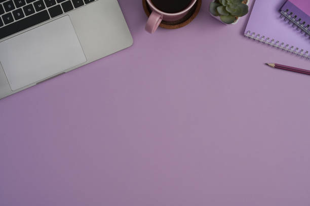 istock Modern workplace with laptop, notebook and coffee cup on purple background. Top view, Flat lay, Copy space. 1393512649