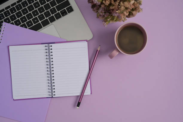 istock Flat lay computer laptop, coffee cup, notebook and pen on purple background. 1393512650