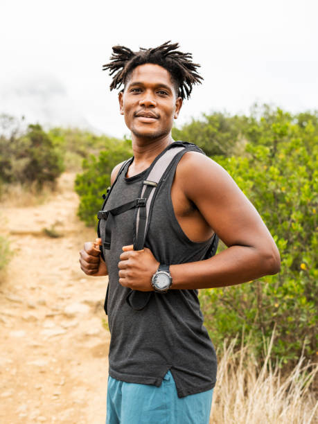 istock Smiling young man standing on a trail during a hike 1393514447