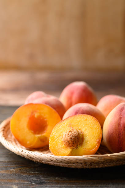 istock Peach fruit in basket on wooden background 1393516027