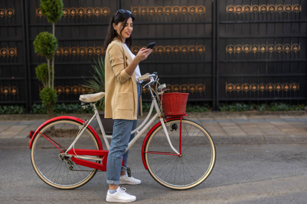 istock Young female tourist using phone while exploring city on vintage bicycle 1393517625