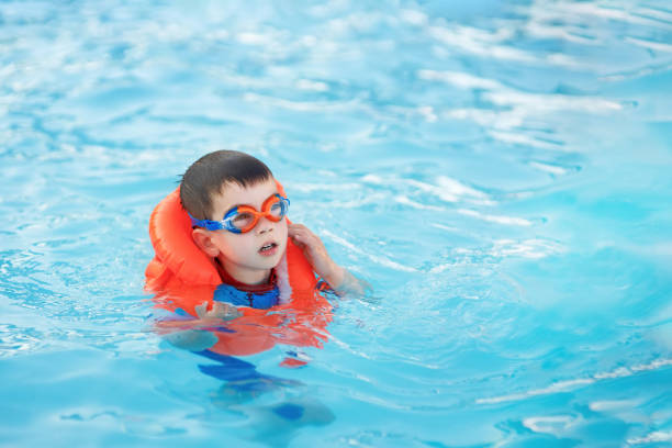 istock little boy learn to swim in the pool 1393517767