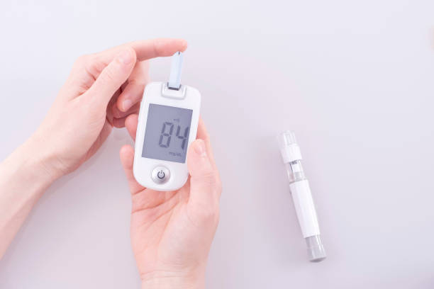 ヒトはグルコメーターを用いて、指から血糖値を測定および試験した。 - insulin food blood sugar test diabetes ストックフォトと画像