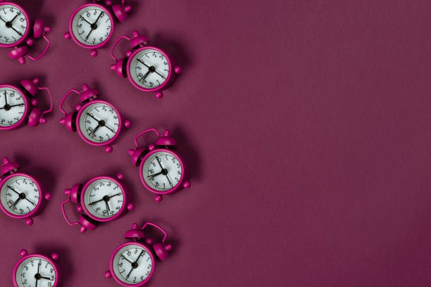 Clocks on pink background stock photo