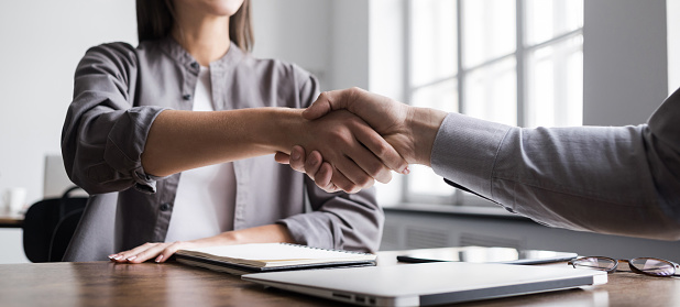 Young business people shaking hands in the office. Business etiquette, congratulation, meeting, job interview, new business, startup, employee concepts