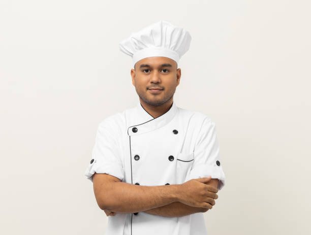 istock Smiling Young handsome asian man chef in uniform with hat standing posting looking at camera on isolated white background. Cooking man Occupation chef or baker People in kitchen restaurant and hotel. 1393528092
