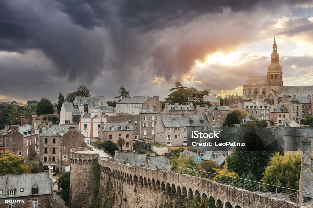 Dinan old town city in Brittany, France Dinan old town city in Brittany, France, cityscape of house's roofs and cathedral. Dinan Stock Photo