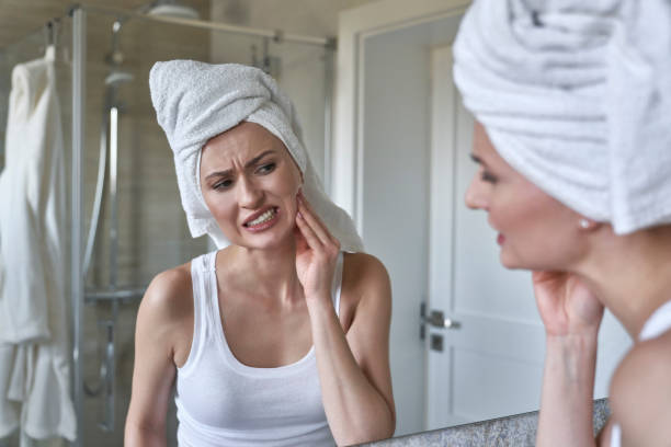 Caucasian woman  in the bathroom having a strong toothache stock photo