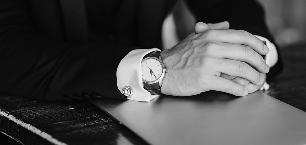 close-up of the hands of a successful man with a watch and laptop. business concept