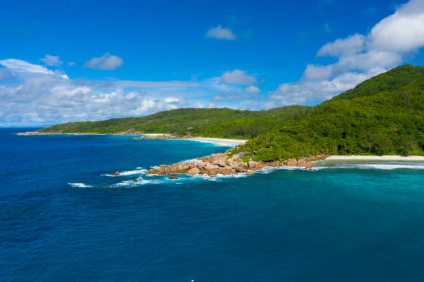 Aerial view from the ocean at coastline of seychlles island with granit rocks and sand beaches on beautiful sunny vacation day