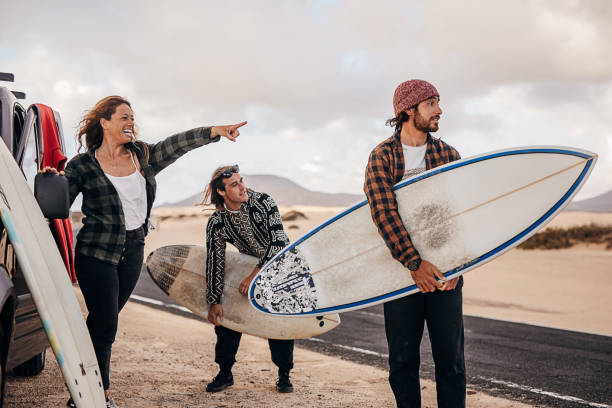 istock Three friends taking surfboards and going to beach to surf 1393547979