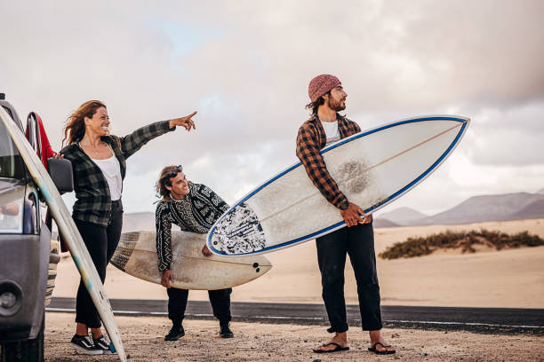 istock Three friends taking surfboards and going to beach to surf 1393548003