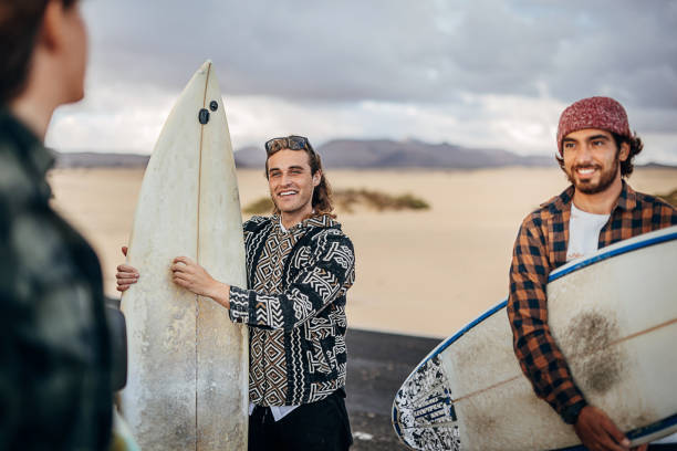 istock Three friends taking surfboards and going to beach to surf 1393548893