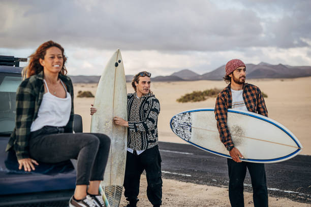 istock Three friends taking surfboards and going to beach to surf 1393549017